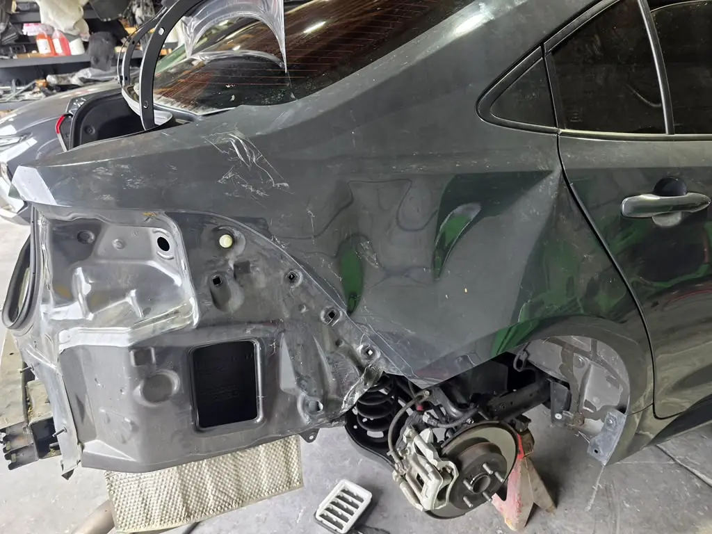 Toyota Corolla with a crushed rear quarter panel, before repair