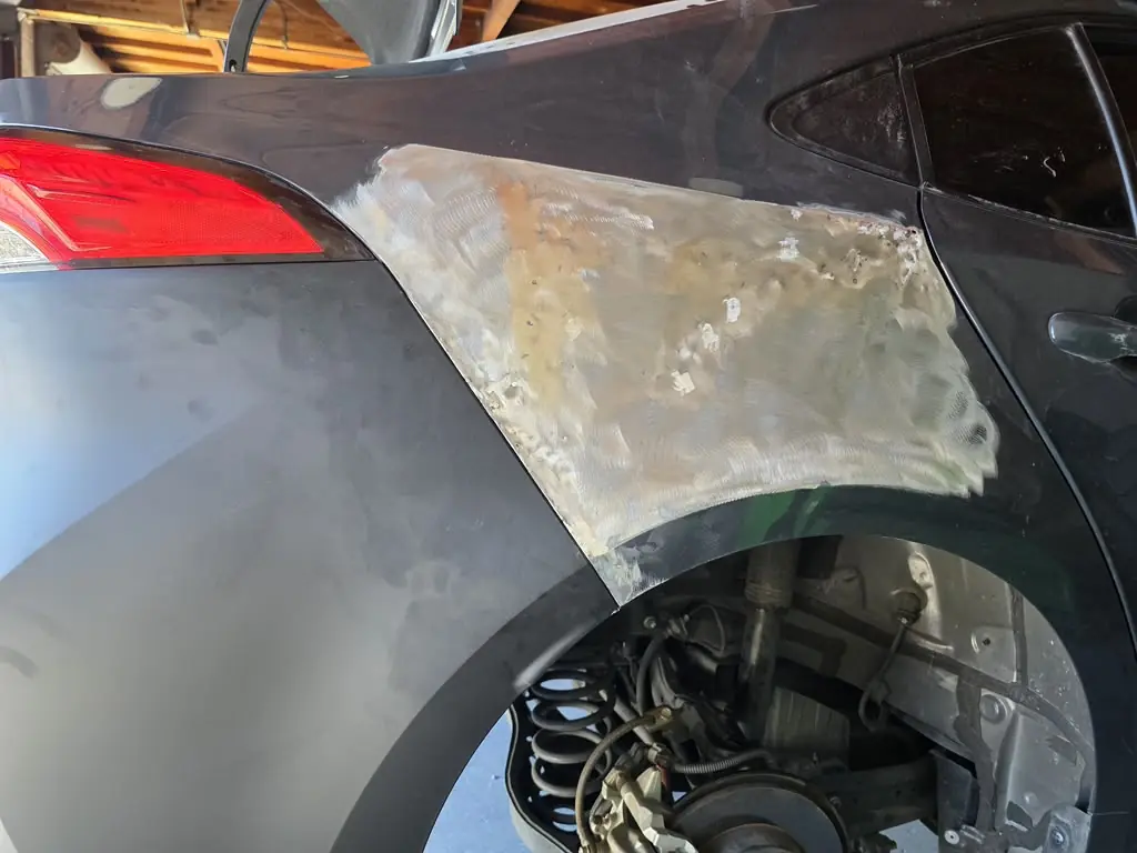 Rear quarter panel reshaped and smoothed with body filler