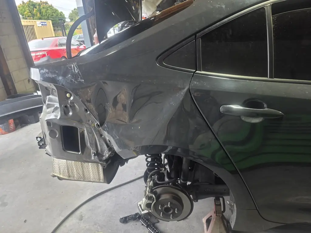Toyota Corolla rear quarter panel crushed, with the bumper removed